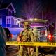 Armed police officers behind yellow crime scene tape