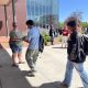 People outside modern building exchanging a flyer