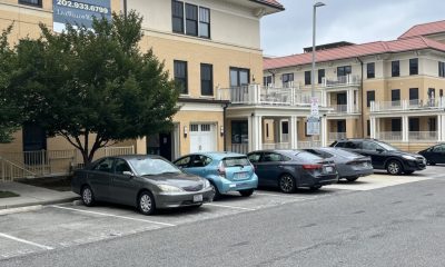 Apartment building with parking lot and leasing sign