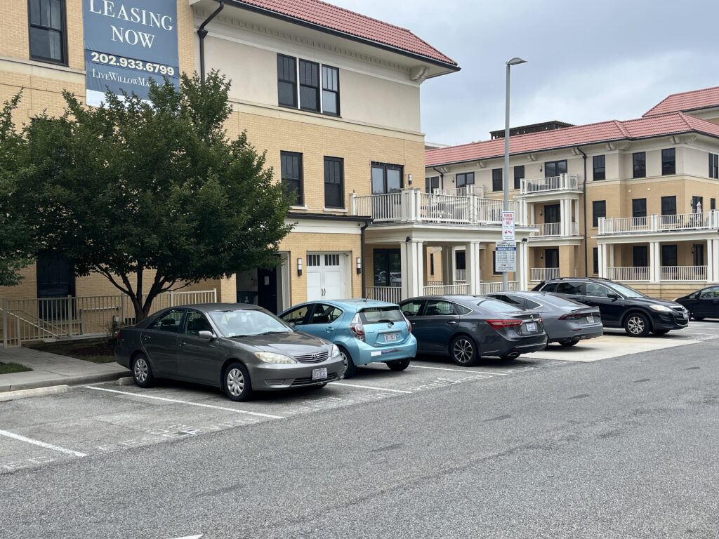 Apartment building with parking lot and leasing sign