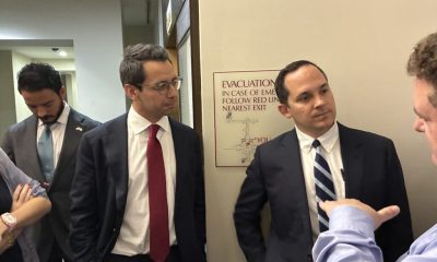 Men in suits discussing in office hallway