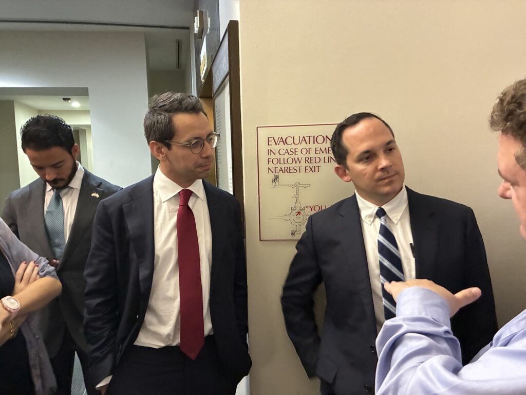 Men in suits discussing in office hallway