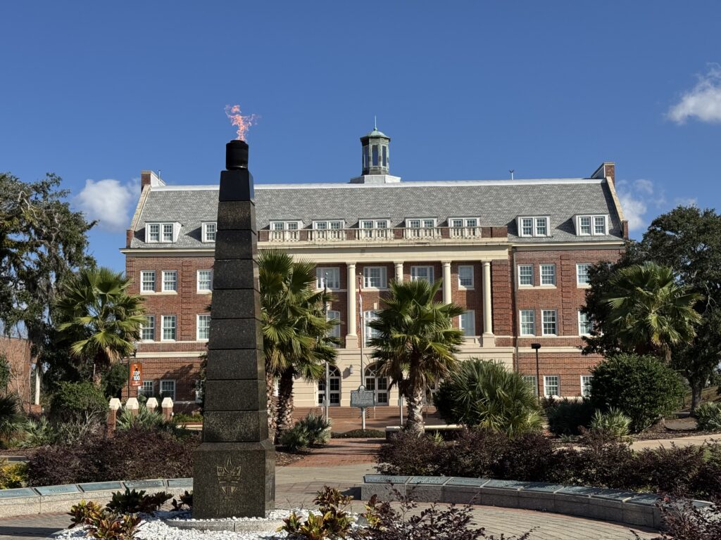 Brick academic building with flaming obelisk monument