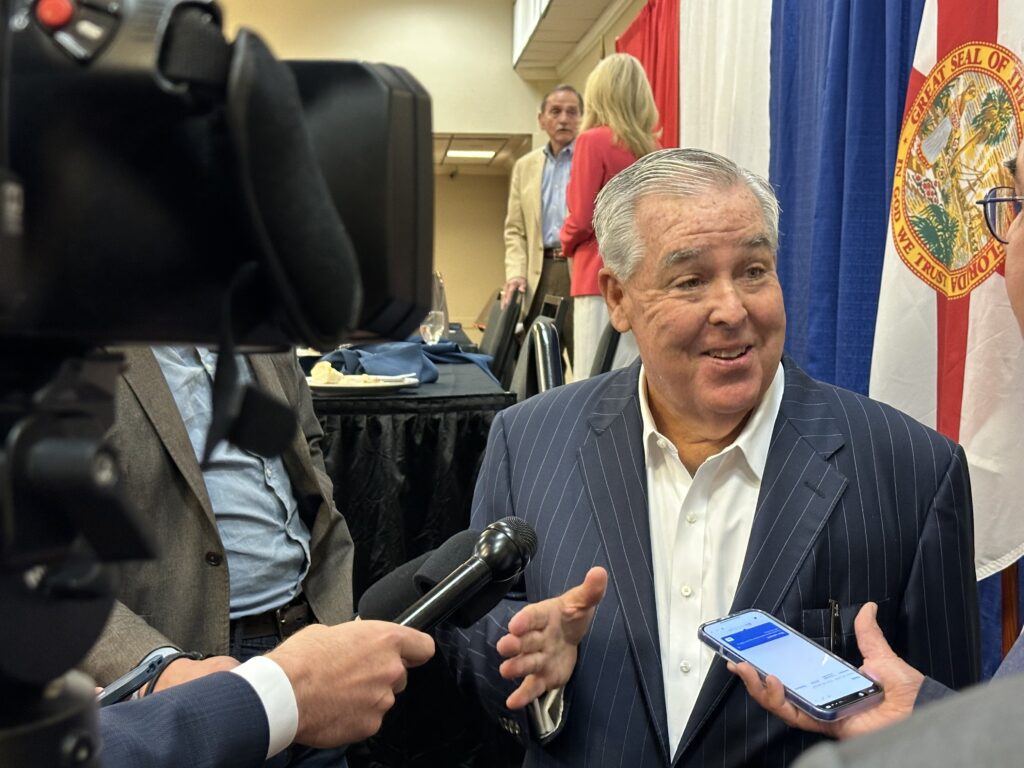 Man speaking to reporters at press event