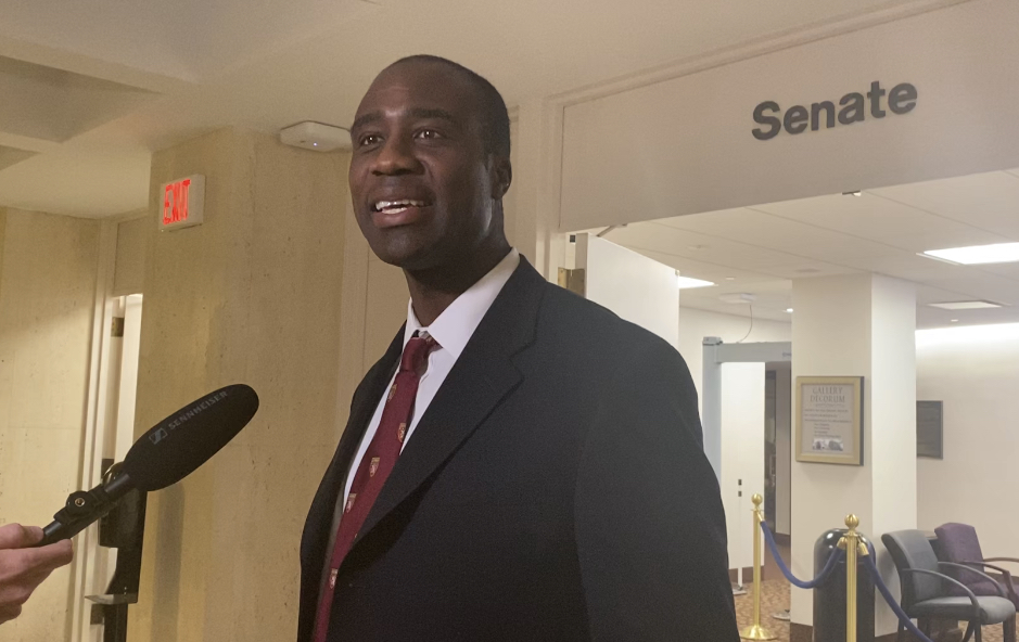 Man speaking near Senate office hallway microphone