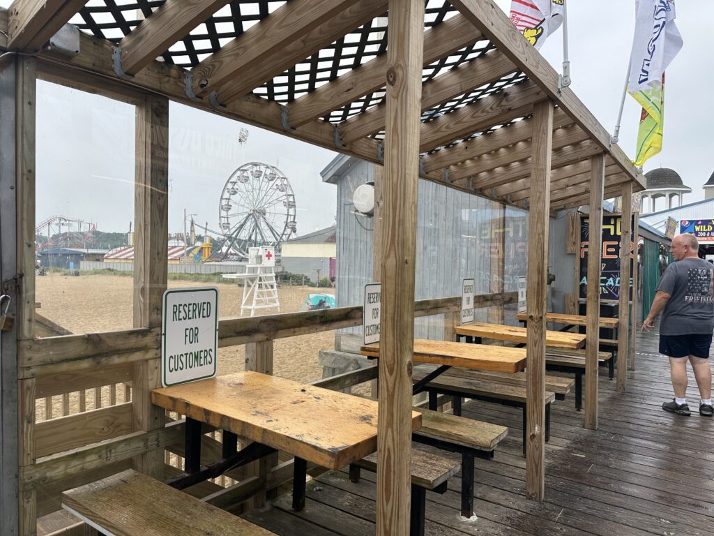 Covered boardwalk seating near beach amusement park