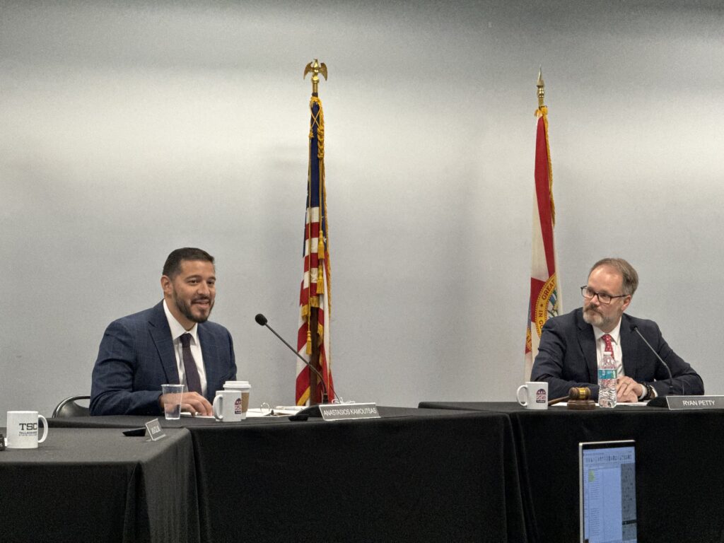 Two men speaking at formal meeting table
