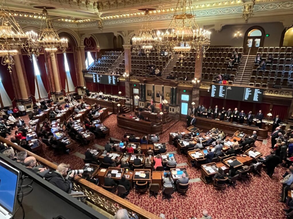 Ornate legislative chamber during session with lawmakers seated