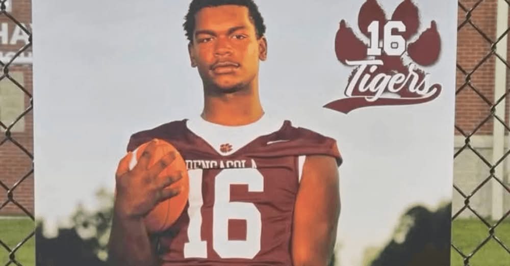 Football player holding ball in Tigers jersey
