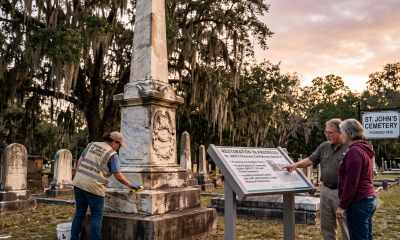 Worker restoring monument at historic cemetery at sunset