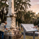 Worker restoring monument at historic cemetery at sunset