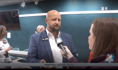 Man being interviewed by reporter indoors