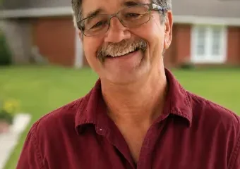 Smiling man in red shirt outdoors