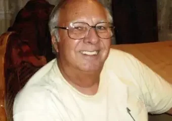 Smiling elderly man wearing glasses indoors