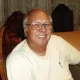 Smiling elderly man wearing glasses indoors