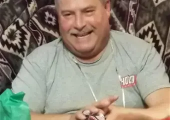 Smiling man holding small gift on couch
