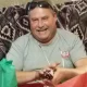 Smiling man holding small gift on couch