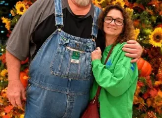 Man and woman posing before fall pumpkin display