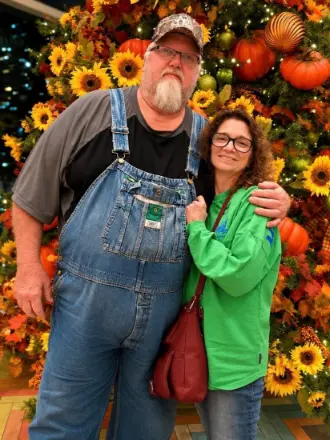 Man and woman posing before fall pumpkin display