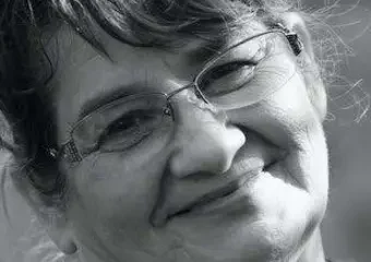Smiling older woman wearing glasses, black-and-white portrait