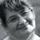 Smiling older woman wearing glasses, black-and-white portrait