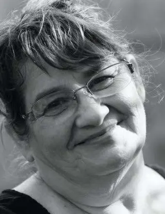 Smiling older woman wearing glasses, black-and-white portrait