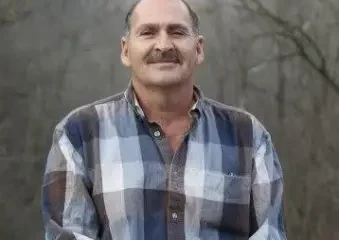 Man in plaid shirt standing outdoors