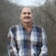 Man in plaid shirt standing outdoors