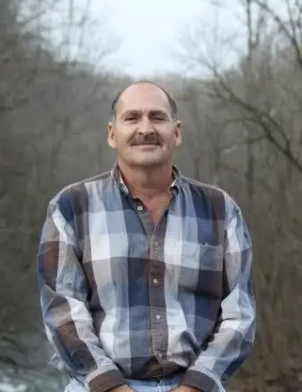 Man in plaid shirt standing outdoors