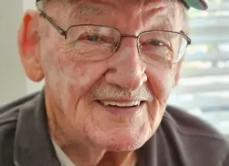 Smiling elderly man wearing U.S. Navy cap