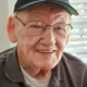 Smiling elderly man wearing U.S. Navy cap