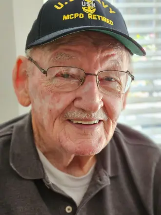 Smiling elderly man wearing U.S. Navy cap