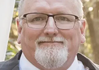 Older man with glasses and white beard outdoors
