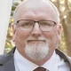 Older man with glasses and white beard outdoors