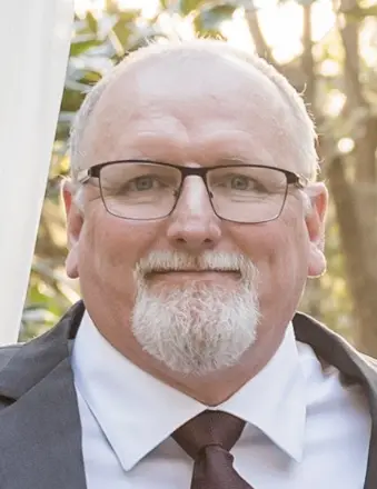 Older man with glasses and white beard outdoors