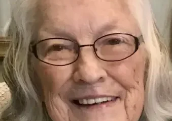 Smiling elderly woman with white hair and glasses