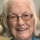 Smiling elderly woman with white hair and glasses