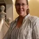 Woman smiling by staircase indoors