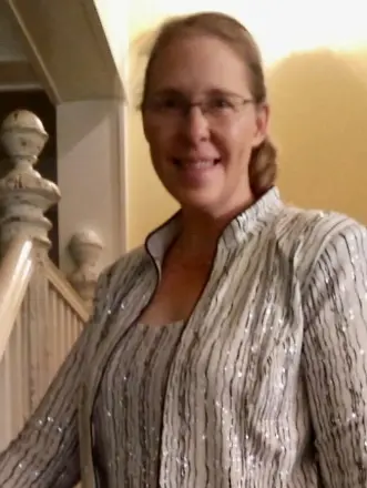 Woman smiling by staircase indoors