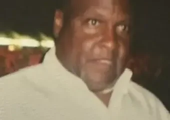Man in light shirt against dark background