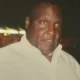 Man in light shirt against dark background