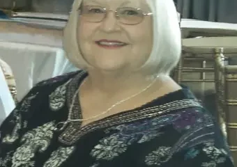 Smiling elderly woman with white bob haircut and glasses