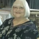 Smiling elderly woman with white bob haircut and glasses