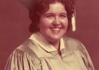 Smiling graduate in cap and gown portrait