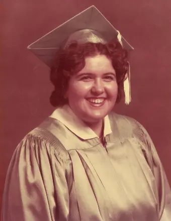 Smiling graduate in cap and gown portrait