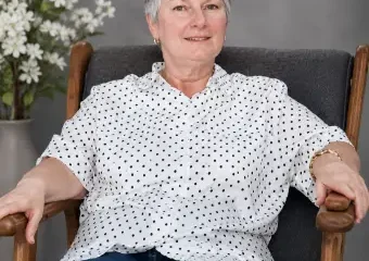 Older woman sitting in armchair, smiling