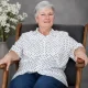 Older woman sitting in armchair, smiling