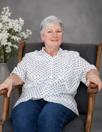 Older woman sitting in armchair, smiling