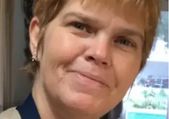 Smiling woman with short blonde hair indoors