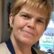 Smiling woman with short blonde hair indoors
